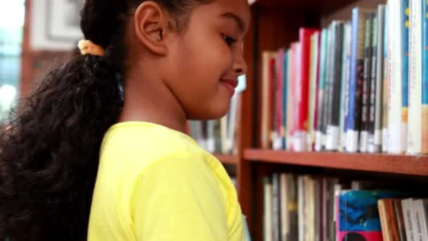 Маленькая девочка в библиотеке — стоковое видео