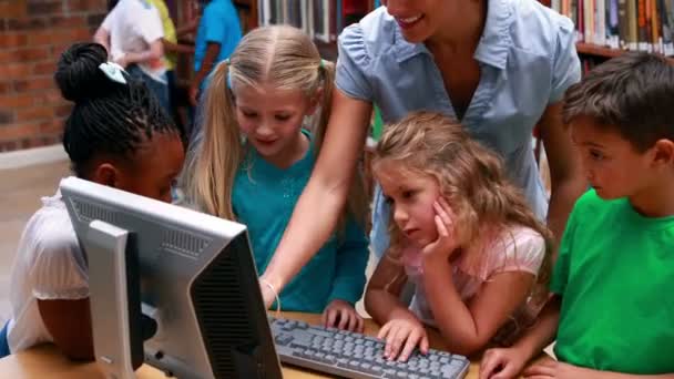 Учні дивляться на комп'ютер у бібліотеці — стокове відео