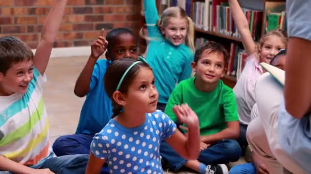 Žáky naslouchat jejich učitel v knihovně — Stock video