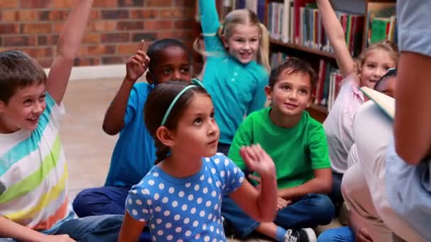 Gli alunni ascoltano il loro insegnante in biblioteca — Video Stock