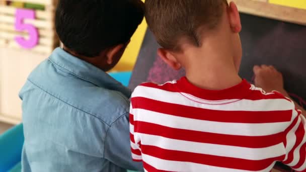 Мальчики рисуют на мини-доске — стоковое видео