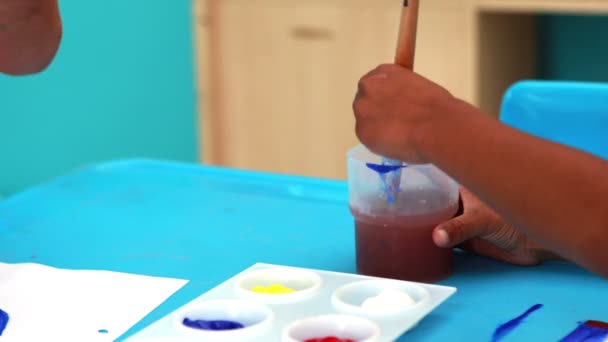 Boys painting at table in classroom — Stock Video