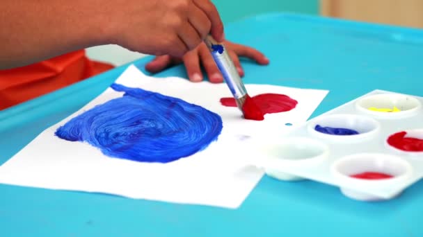 Pintura de menino à mesa em sala de aula — Vídeo de Stock