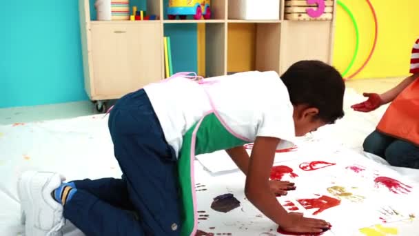 Niños pintando a mano sobre papel en el aula — Vídeo de stock
