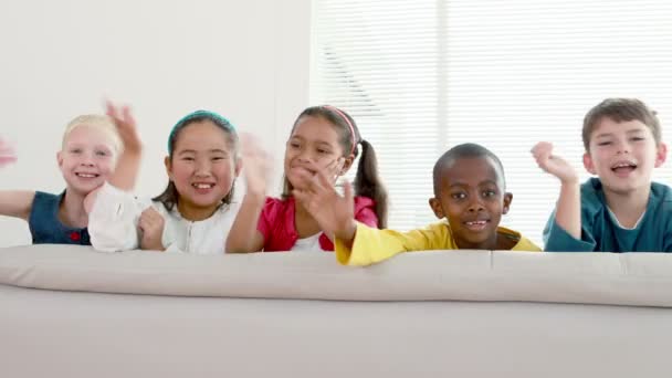 Children waving on the sofa — Stock Video