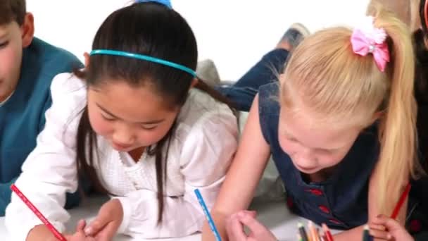 Niños acostados en el suelo dibujo sobre papel — Vídeo de stock