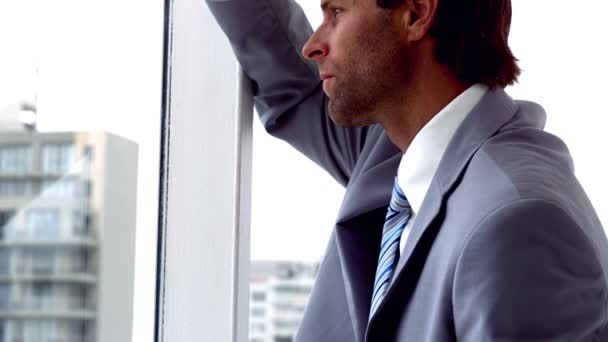 Hombre de negocios infeliz mirando por la ventana — Vídeos de Stock