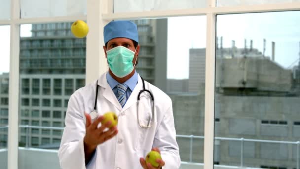 Doctor in mask juggling green apples — Stock Video