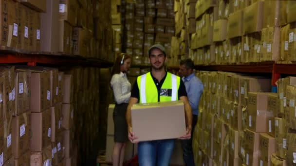 Trabajador de almacén llevando una caja — Vídeos de Stock