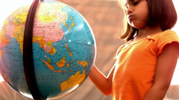 Little girl looking at globe in classroom — Stock Video