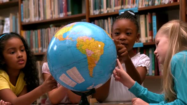 Chicas mirando el globo en la biblioteca — Vídeos de Stock