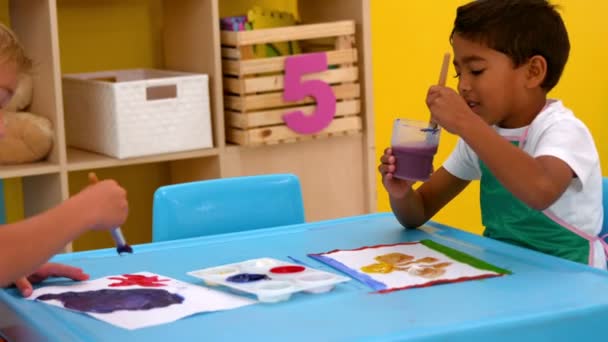 Niños pintando en la mesa en el aula — Vídeo de stock