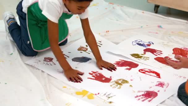 Meninos pintando com as mãos deitadas no papel — Vídeo de Stock