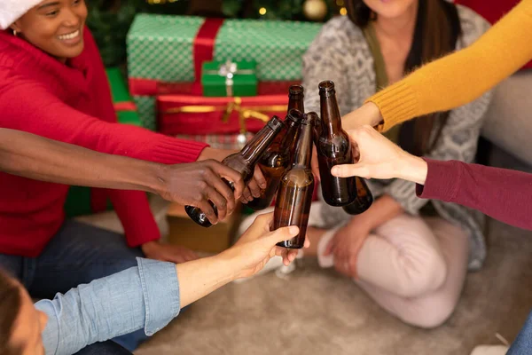 クリスマスの時間にビールで乾杯する幸せな多様な女性と男性の友人 クリスマスのお祝い友達と家でお祝いする — ストック写真