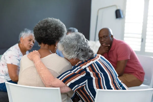 对白人老年女性拥抱非洲裔美国女性朋友并支持她的回顾 老年人的健康 支助和生活方式 — 图库照片