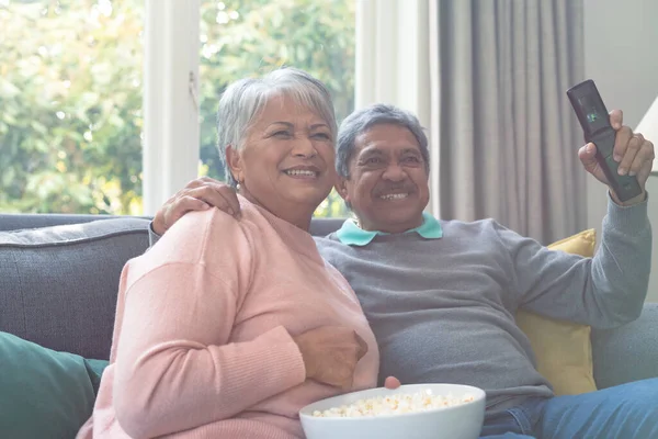 Δύο Διαφορετικοί Ηλικιωμένοι Κάθονται Στον Καναπέ Βλέπουν Τηλεόραση Και Διασκεδάζουν — Φωτογραφία Αρχείου