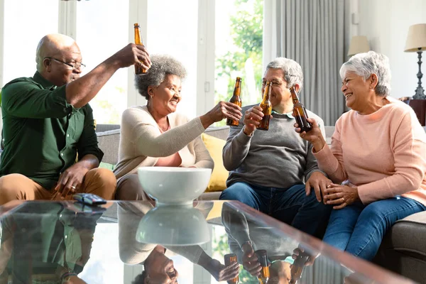 两对年长的夫妇坐在沙发上喝啤酒 玩得很开心 退休后的生活方式随着科技的进步而放松 — 图库照片