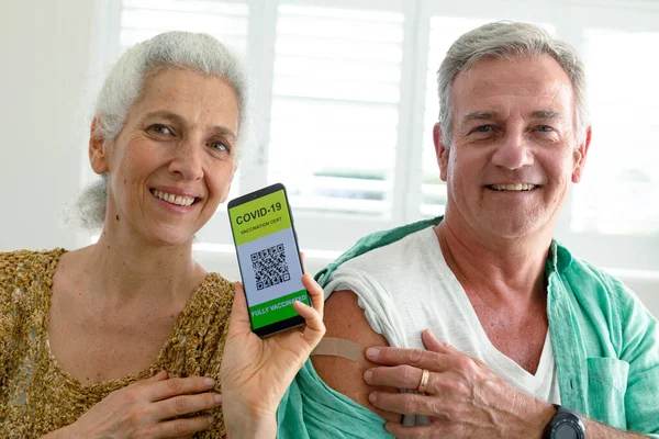 Gülümseyen Kafkas Kıdemli Çift Ekranda Covid Aşı Pasaportlu Akıllı Telefon — Stok fotoğraf