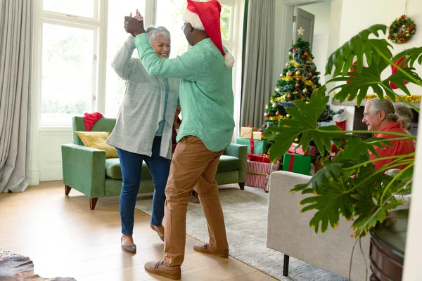 圣诞佳节快乐多姿多彩的老夫妇在客厅里跳舞 圣诞节庆祝活动 和朋友们在家里庆祝 — 图库照片