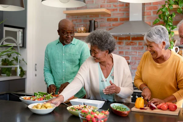 一群快乐多样的老年男女朋友在家里一起做饭 做饭和与家里的朋友交往 — 图库照片