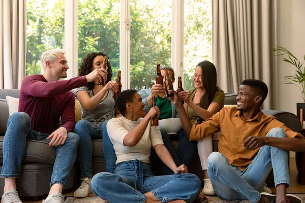 一群快乐多样的男女朋友一起在家里看电视和喝啤酒 与家里的朋友交往 — 图库照片