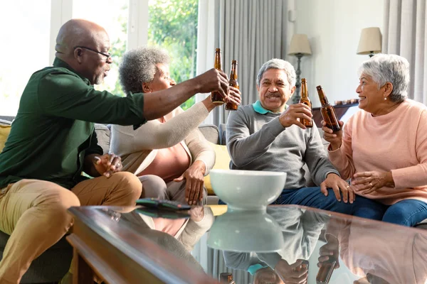 两对年长的夫妇坐在沙发上喝啤酒 玩得很开心 退休后的生活方式随着科技的进步而放松 — 图库照片