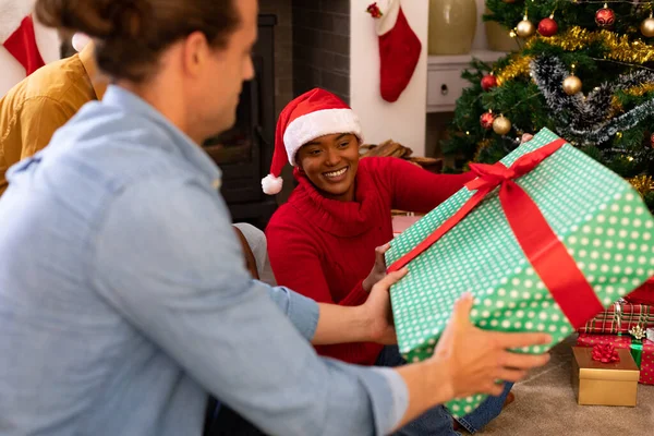 クリスマスの時間にプレゼントを共有する幸せな多様な女性と男性の友人 クリスマスのお祝い友達と家でお祝いする — ストック写真