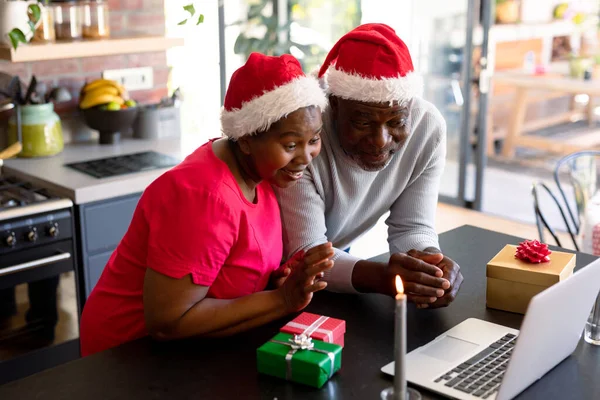 快乐的非洲裔美国老年夫妇在圣诞节期间在厨房的笔记本电脑上有视频通话 退休生活方式 圣诞节庆祝活动和通信技术 — 图库照片