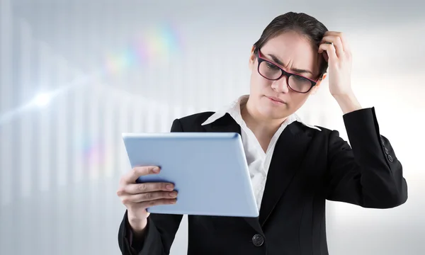 Denkende Geschäftsfrau blickt auf Tablet-PC — Stockfoto