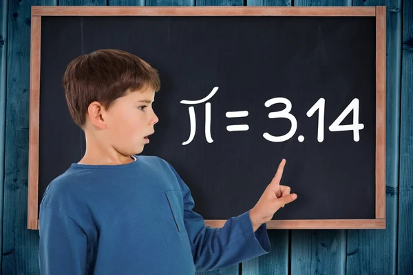 Boy pointing against blackboard — Stock Photo, Image