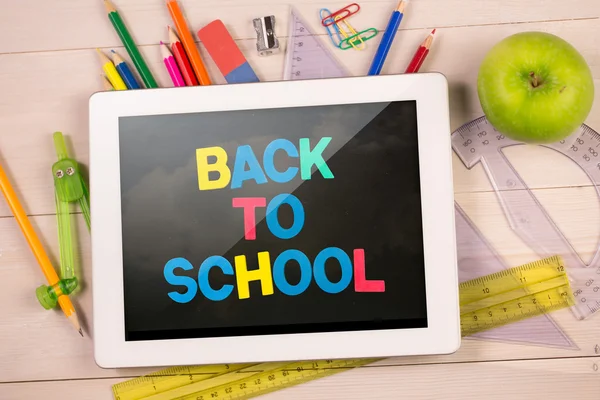 Composite image of digital tablet on students desk — Stock Photo, Image