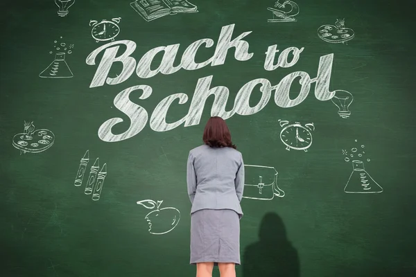 Businesswoman against green chalkboard — Stock Photo, Image