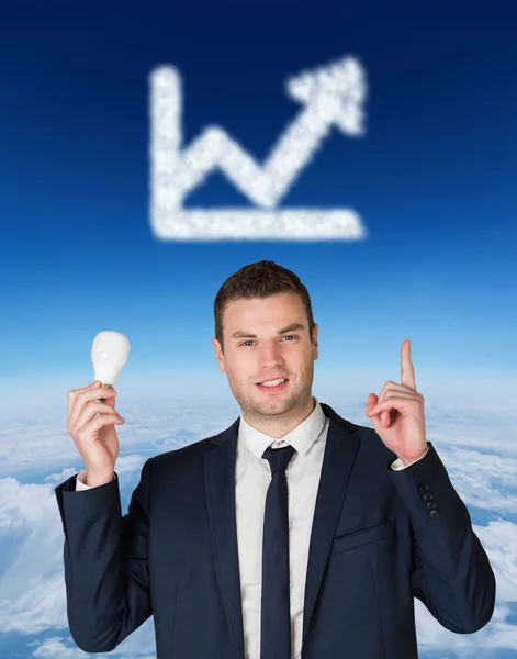 Businessman holding light bulb and pointing — Stock Photo, Image
