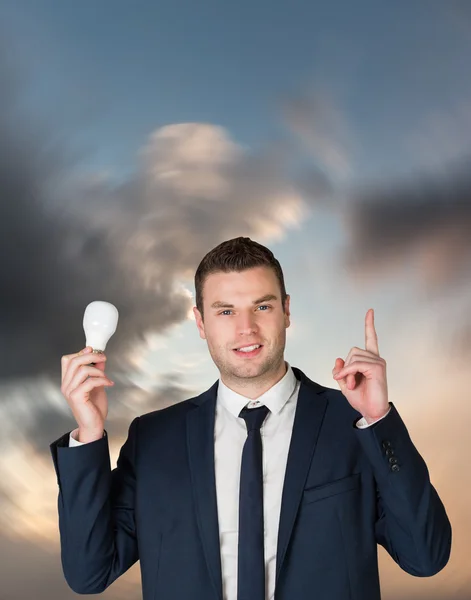 Businessman holding light bulb and pointing — Stock Photo, Image