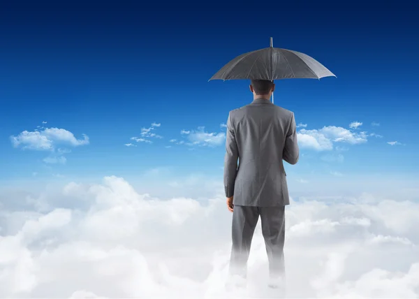 Businessman standing under umbrella — Stock Photo, Image