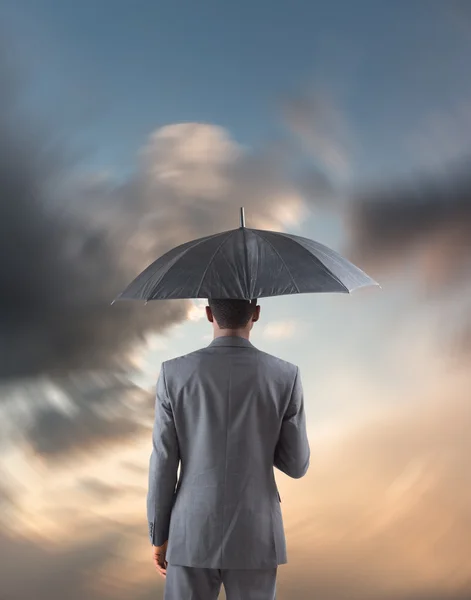 Zakenman permanent onder paraplu — Stockfoto