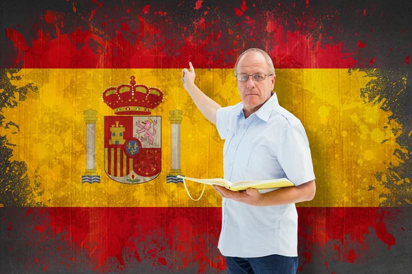 Insegnante che tiene il libro contro la bandiera della Spagna — Zdjęcie stockowe