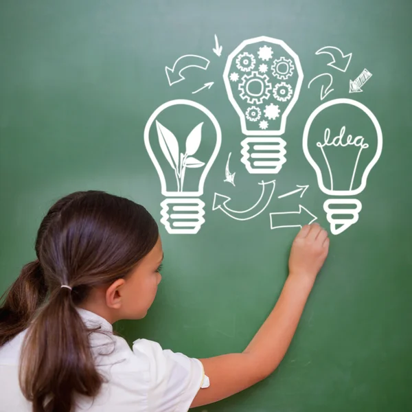 Cute pupil writing on chalkboard — Stock Photo, Image