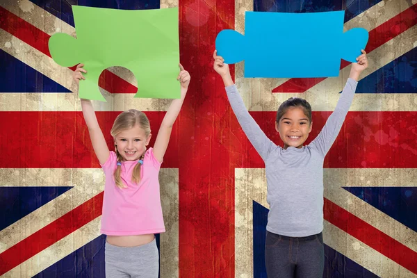 Elementary pupils holding jigsaw pieces — Stock Photo, Image