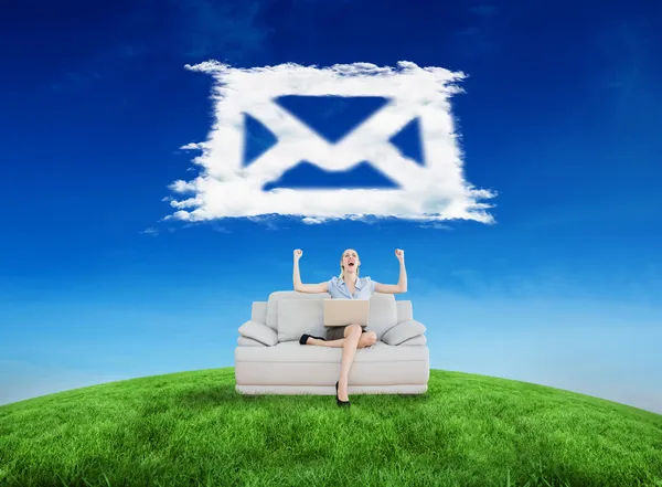 Businesswoman sitting on couch against cloud email — Stock Photo, Image