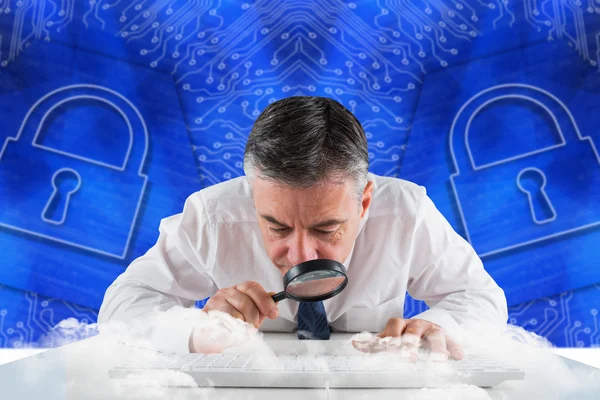 Businessman examining with magnifying glass — Stock Photo, Image