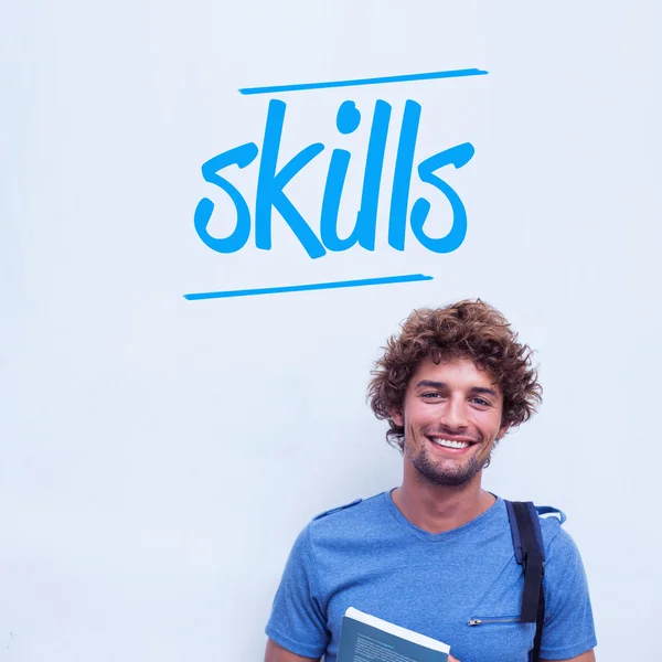 Skills against happy student holding book — Stock Photo, Image