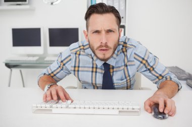 Focused casual businessman working at his desk clipart