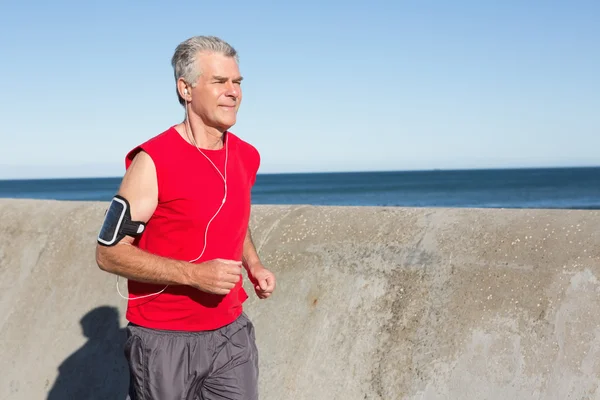 Aktiv senior man jogging på piren — Stockfoto