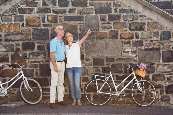 Lyckliga äldre par går för en cykel rida i staden — Stockfoto