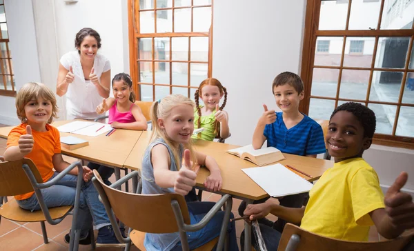 Öğretmen öğrencilerin masa ile ayakta — Stok fotoğraf