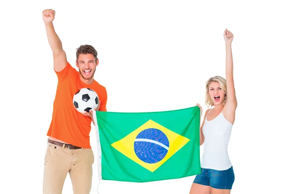 Excited football fan couple holding brazil flag — Stock Photo, Image