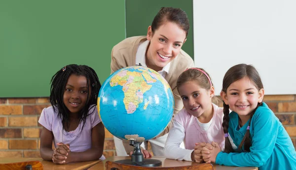 Pupils and teacher in classroom with globe — Stock Photo, Image