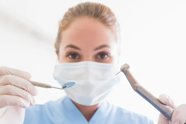 Dentista en máscara quirúrgica sosteniendo herramientas sobre el paciente — Foto de Stock