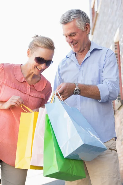 Feliz pareja de ancianos mirando sus compras —  Fotos de Stock